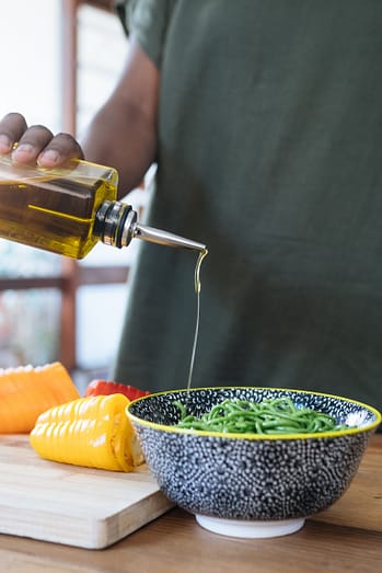 man putting oil in a salade