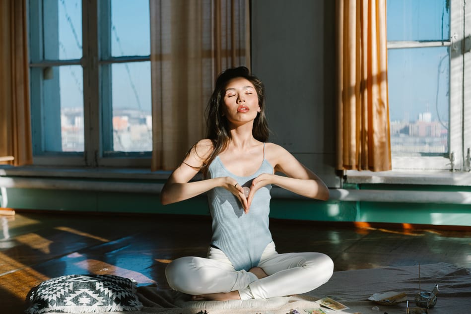 a young woman meditating in her house 