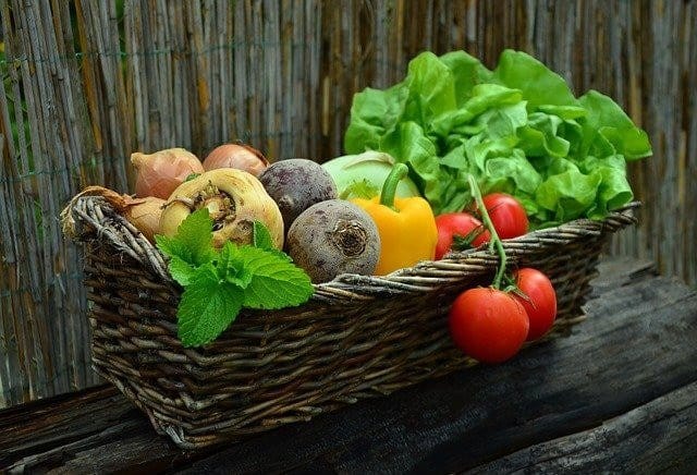 a basket with different colored vegetables