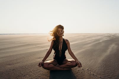 woman sitting on the beach, meditating