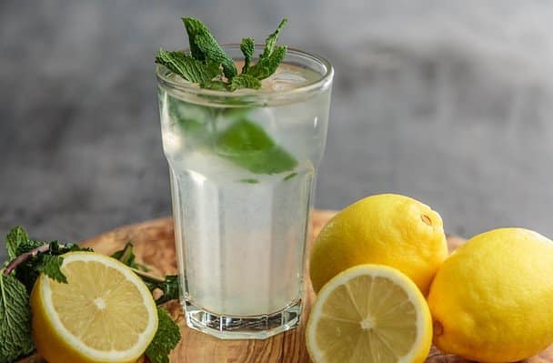 a glass of water with lemons and mint