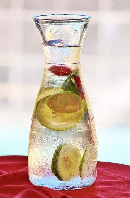 a carafe of water with lemons